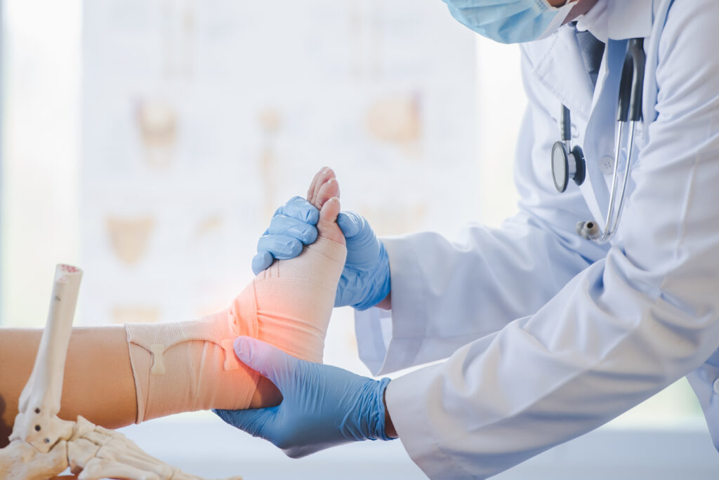 Close-up of pictures of a male orthopedic doctor or orthopedic doctor Wear a medical mask and medical gloves. Going to analyze the cause of ankle bone degeneration In his office at the hospital